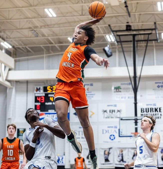 Jaxon Dollar rising above two defenders for a one-handed dunk in an East Lincoln basketball game.